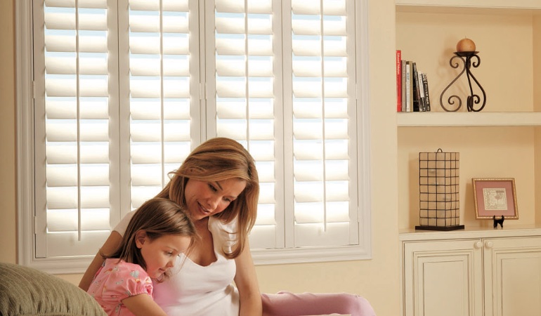 Easy to clean Polywood shutters are perfect cord-free options for children. Mom and daughter in front of window